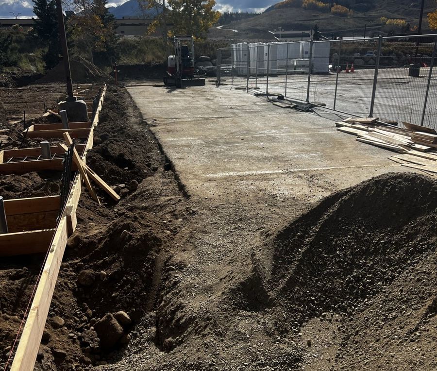 Formed foundations and excavation beside a parking lot